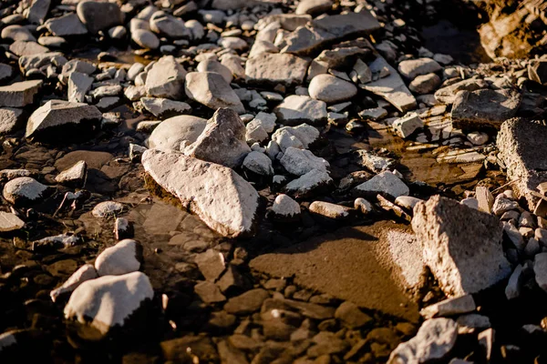 Stone beneath  river water, river water waves brushing through the stones fresh water stream in mountain brook, close up