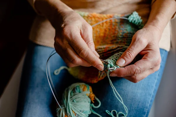 Woman Knitting a scarf. Hands holding threads. Colorfull Knitting