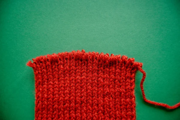 Bufanda Roja Brillante Con Agujas Punto Sobre Fondo Verde Contraste —  Fotos de Stock