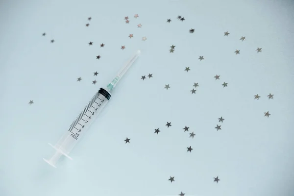 Transparent syringe with a needle, on a background. No liquid in the syringe. Single use only.