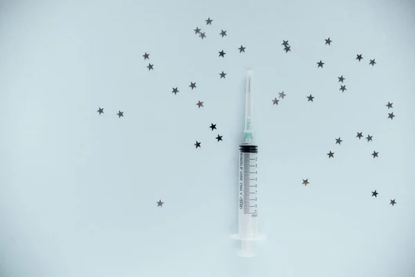 Transparent syringe with a needle, on a background. No liquid in the syringe. Single use only.