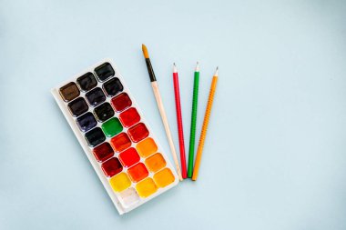 Yaratıcı kavramı, bir fırça ve açık mavi renkli kalemler Suluboyalar. Yatay. Yaratıcı, sanatsal ve renkli duvar kağıdı.