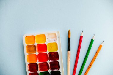 Yaratıcı kavramı, bir fırça ve açık mavi renkli kalemler Suluboyalar. Yatay. Yaratıcı, sanatsal ve renkli duvar kağıdı.