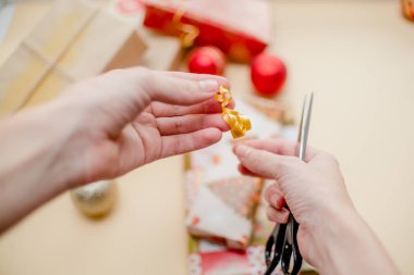 Erkek hediyeleri tutarak ve hediye ambalaj eller. Hediyeler ve Noel topları, tatil kavramı. Kırmızı, yeşil ve altın kağıt. 