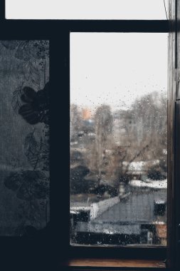 Yağmurlu havalarda eski ahşap pencere. Yağmur damlaları arka cam ve köy görünümünde her yerinde. Erken sonbahar