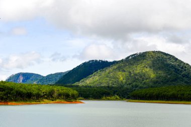 Göl ve nehir ön planda bazı Dağları ile. Bulutlar ve tepeler ile mavi gökyüzü
