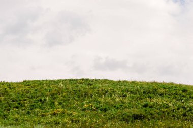 Yeşil tepeler ufuk bulutlarda ile. Mavi gökyüzü ve beyaz bulutlar. 