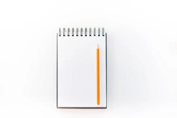 Beyaz eskiz defteri turuncu kalem ve mavi çalar saat ile. Eğitim ve planlama kavramı, beyaz arka plan. Mock-up kavramı. Beyaz arka plan, izole, yakın çekim 