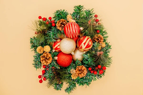 Christmas Wreath Made of Naturalistic Looking Pine Branches Decorated with Gold Stars and Bubbles.Christmas wallpaer pine christmas wreath. Christmas fur tree balls. Presents, red and golden colors.