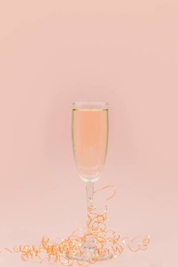 Bir bardak şampanya kabarcıklar ile. Noel topları ve altın ışıkları açık arka plan.