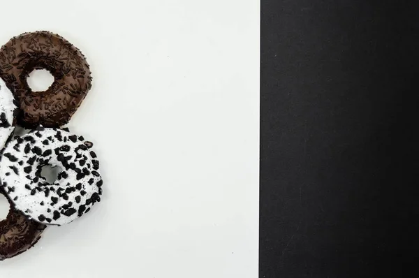 Donuts con chocolate glaseado con espolvoreos donuts aislados sobre fondo blanco negro abstracto — Foto de Stock