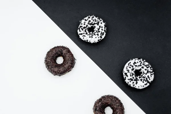 Donuts con chocolate glaseado con espolvoreos donuts aislados sobre fondo blanco negro abstracto — Foto de Stock