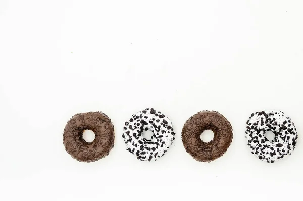 Donuts con chocolate glaseado con espolvoreos donuts aislados sobre fondo blanco negro abstracto — Foto de Stock