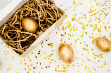 Altın yumurta kutusundaki metinle beyaz zemin üzerine altın yıldız. Paskalya tatil kavramı arka plan boşaltmak Üstten Görünüm 