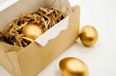 Altın yumurta kutusundaki metinle beyaz zemin üzerine altın yıldız. Paskalya tatil kavramı arka plan boşaltmak Üstten Görünüm 