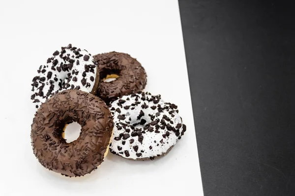 Donuts con chocolate glaseado con espolvoreos donuts aislados sobre fondo blanco negro abstracto — Foto de Stock