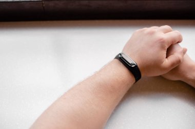 Adam fitness bileziği takıyor. Bir adamın elinde akıllı saat. Emekli Fitness Tracker kullanarak. Yatay üst görünüm everal nesneleri