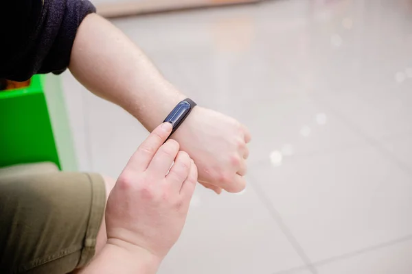 O homem está a usar uma pulseira fitness. Vigia inteligente na mão de um homem. Pensionista usando Fitness Tracker. Visão horizontal superior objetos everais — Fotografia de Stock