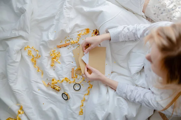 Mãos femininas segurando cartão de presente, envelope e caixa de presente sobre o b — Fotografia de Stock