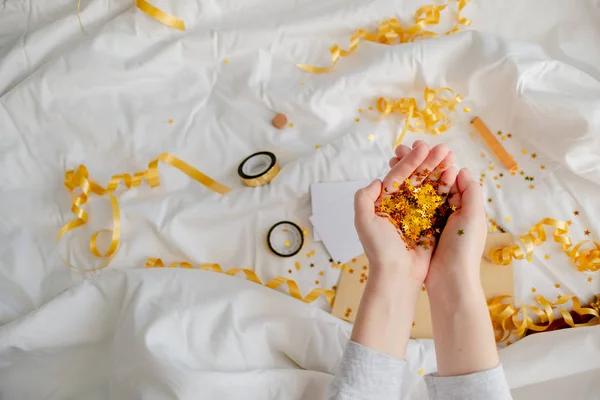 Heller festlicher goldener Konfettistern funkelt Frauenhand auf Weiß — Stockfoto