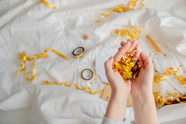 Heller festlicher goldener Konfettistern funkelt Frauenhand auf Weiß — Stockfoto