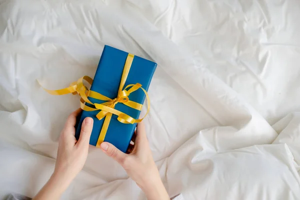 Kadın eli, hediyeleri başucunda tutuyor. Yeni yıl ve noel ortaklığı