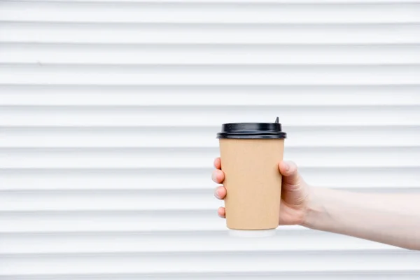 Kahve fincanı kağıt latte ile kadın eli. Bardakta kahve fincanı, paket servis için..