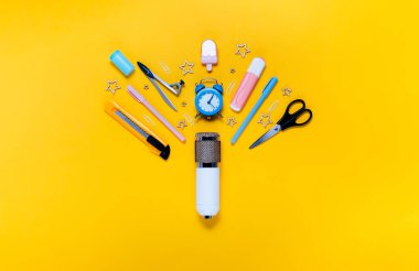 Okul konsepti not defterine, kalem kutusuna, kırtasiyeye ve okul malzemelerine geri dönelim. Üst yatay görünüm telif alanı sarı arkaplan