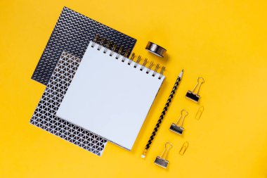 Okul konsepti not defterine, kalem kutusuna, kırtasiyeye ve okul malzemelerine geri dönelim. Üst yatay görünüm telif alanı sarı soyut arkaplan