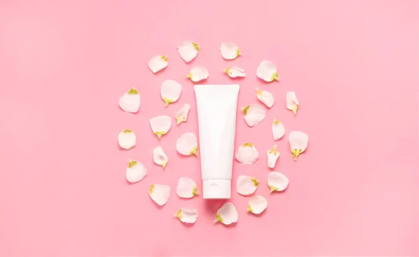 Delicate skin care cosmetic feminine flatlay. Top view Creative composition of face cream ,glass bottles and jars with cosmetic and flowers leaves