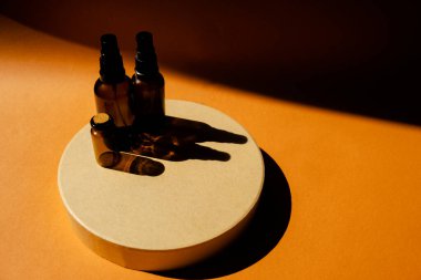 Kozmetik podyumunda yüz estetiği için yeniden kullanılabilir cam şişeler. Üst yatay görünüm soyut arkaplan telif uzayı.