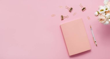 Kırtasiye işi, düz çizgi, yaratıcı kompozisyon. Zarfın üst yatay görünümü, sarmal tıkanma kağıt ataçları ve soyut pembe arkaplan üzerine bir kalem