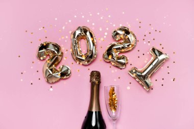 2021 altın folyo balon numaraları, şampanya, yıldız konfetileri, kurdeleler ve bokeh. Üst yatay görünüm fotokopi alanı yeni yıl ve tatil kavramı.