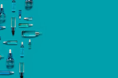 Doğal serumlar ve yüz yağları. Cam bir şişede pipetli kozmetik hidratasyon serumu. Soyut arkaplan üzerinde Hyaluronic asit üst yatay telif uzayı.