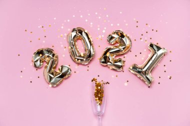 2021 altın folyo balon numaraları, şampanya, yıldız konfetileri, kurdeleler ve bokeh. Üst yatay görünüm fotokopi alanı yeni yıl ve tatil kavramı.
