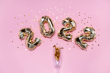 2021 altın folyo balon numaraları, şampanya, yıldız konfetileri, kurdeleler ve bokeh. Üst yatay görünüm fotokopi alanı yeni yıl ve tatil kavramı.