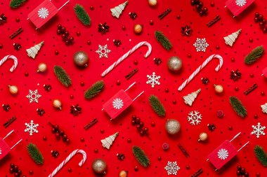 Kırmızı arka planda kış ve yeni yıl oyuncakları olan son moda Noel modelleri. Üst yatay görünüm telif uzayı 