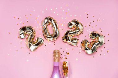 2021 altın folyo balon numaraları, şampanya, yıldız konfetileri, kurdeleler ve bokeh. Üst yatay görünüm fotokopi alanı yeni yıl ve tatil kavramı.