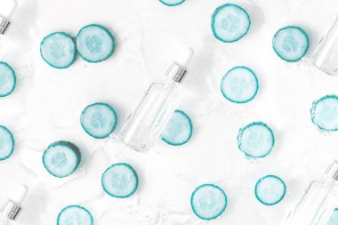 Sıvı kolajen ve hiyalüronik asit içeren cam şişe, hidrasyon derisi. Üst düz görünüm telif uzayı. Soyut su arkaplanı.