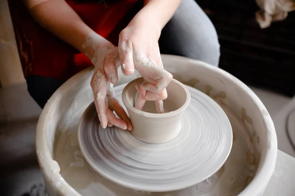 Kvinnliga händer som tillverkar en keramikkopp på ett keramikhjul. Handgjort och hantverkskoncept. Överst på sidan copyspace. — Stockfoto