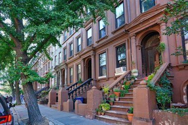 New York City Street with row of old brownstone townhouses clipart