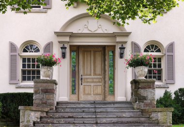 Kapısı sıva kaplı evin, çiçek saksısı ve panjuru olan tahıllı ön kapısı.