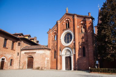 Abbey, Viboldone, tarihi ana kapı ve sütunlar ile Milano eyaletinde içinde. Kilise Viboldone, çan kulesi, kemerler, heykeller ve Milan kırsalında bir güneşli gün boyunca ağaçlar.