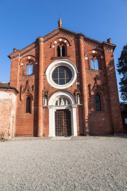 Abbey, Viboldone, tarihi ana kapı ve sütunlar ile Milano eyaletinde içinde. Kilise Viboldone, çan kulesi, kemerler, heykeller ve Milan kırsalında bir güneşli gün boyunca ağaçlar.