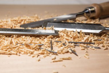 Bir zanaatkar marangozun keski bıçakları ve odun talaşı ve çivi talaşı ile masa.