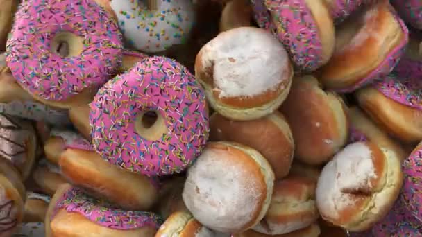 Πτώση διαφόρων ντόνατς σε ροζ φόντο — Αρχείο Βίντεο