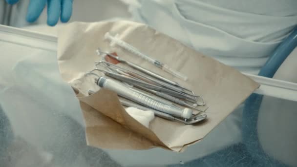 Doctor dentista toma instrumentos de la mesa — Vídeo de stock