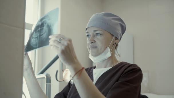 Mujer dentista buscando mandíbula de rayos X — Vídeo de stock