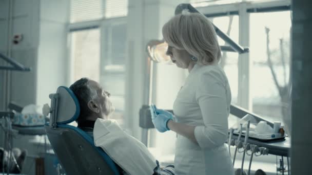 Donna dentista comunica con un cliente — Video Stock