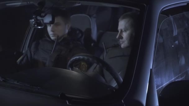 İki polis arabada konuşurken radyo — Stok video